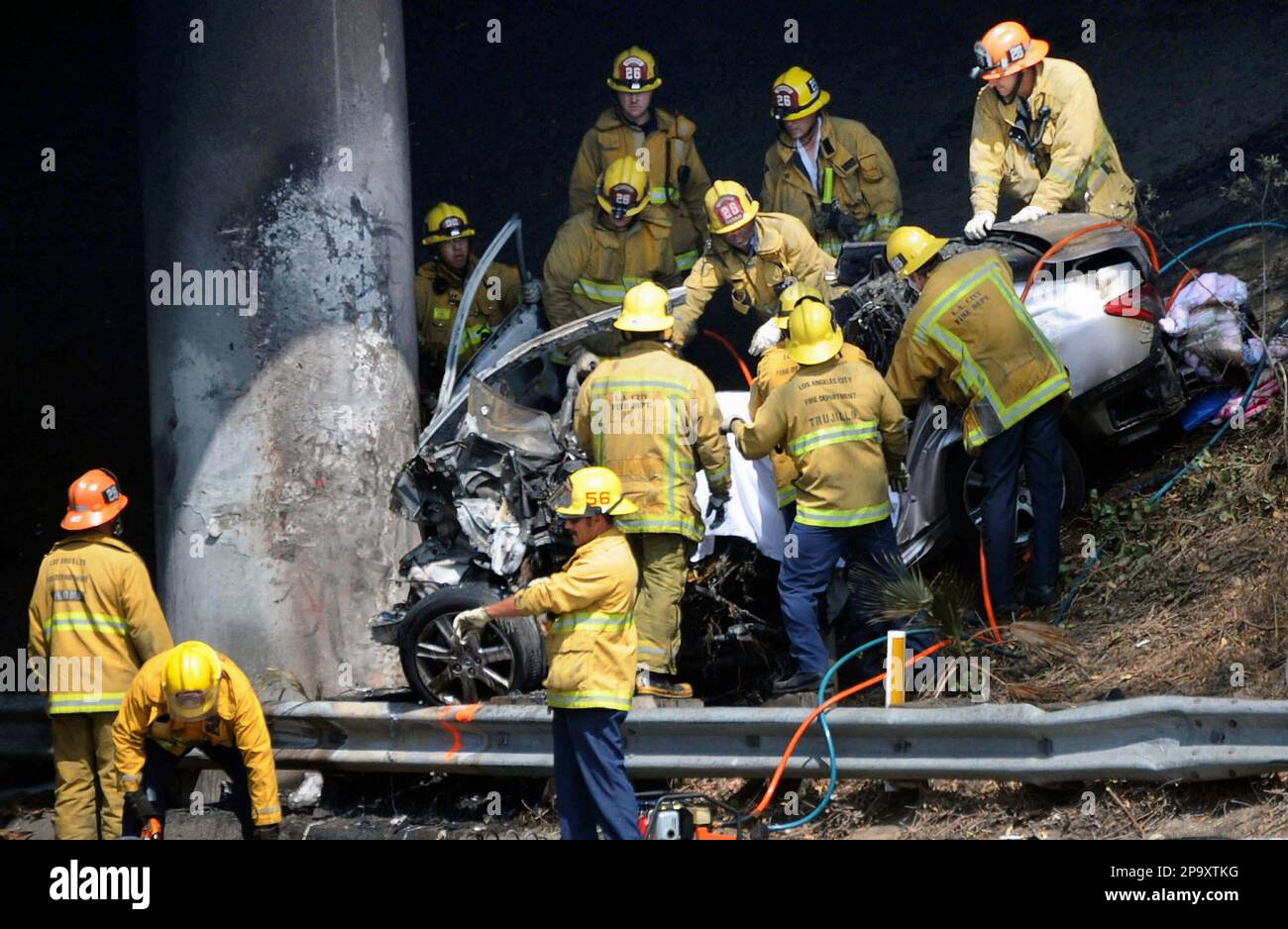 Los Angeles fire fighters remove a driver and passengers from a car ...