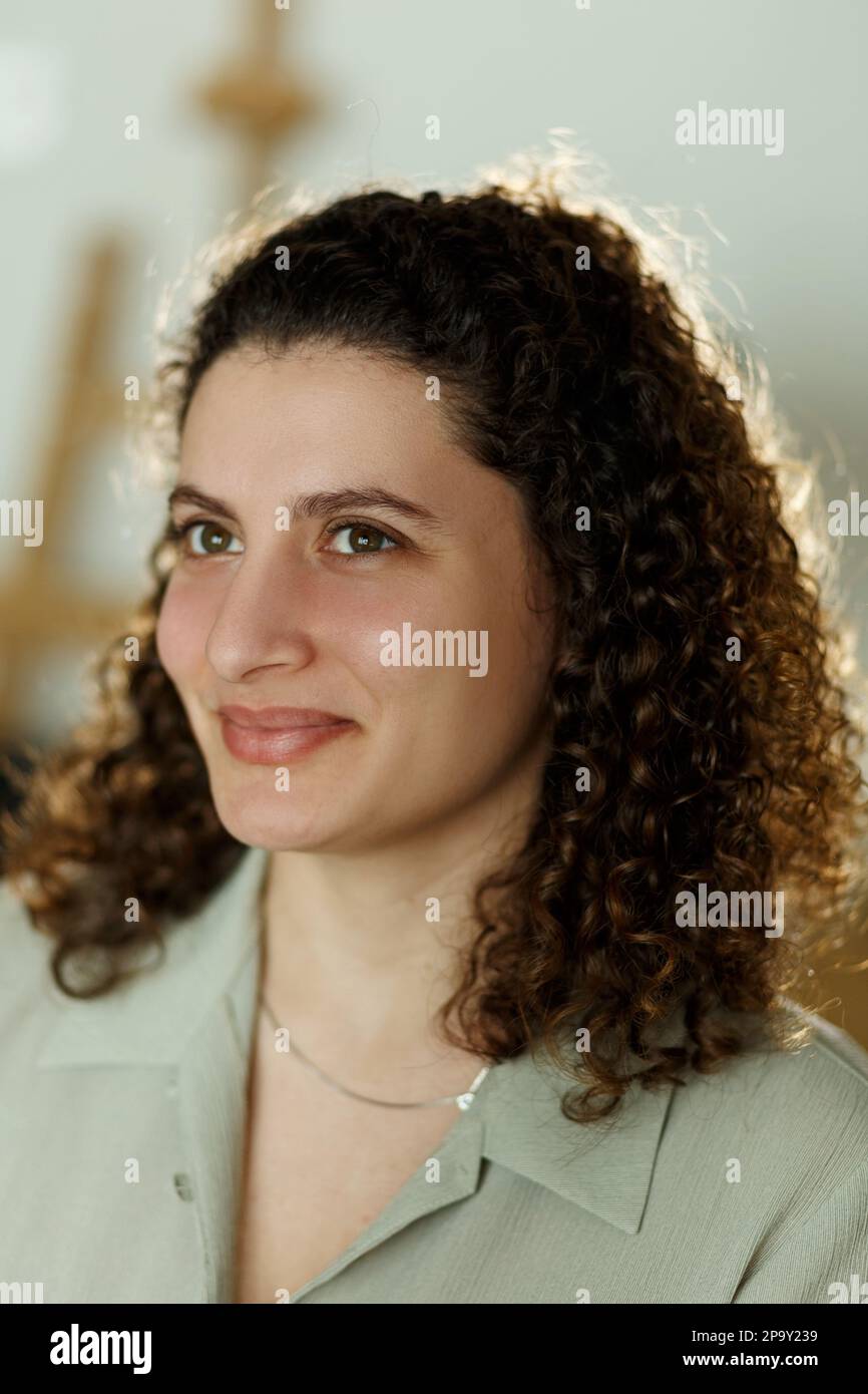 Portrait of a young, curly mixed race student or businesswoman in room in a library or office. Stock Photo