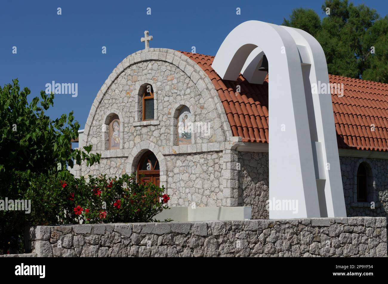 Kolymbia, Rhodes, Greece - May 25, 2019: Stone Orthodox Church with icons on the facade and ventilation system Stock Photo
