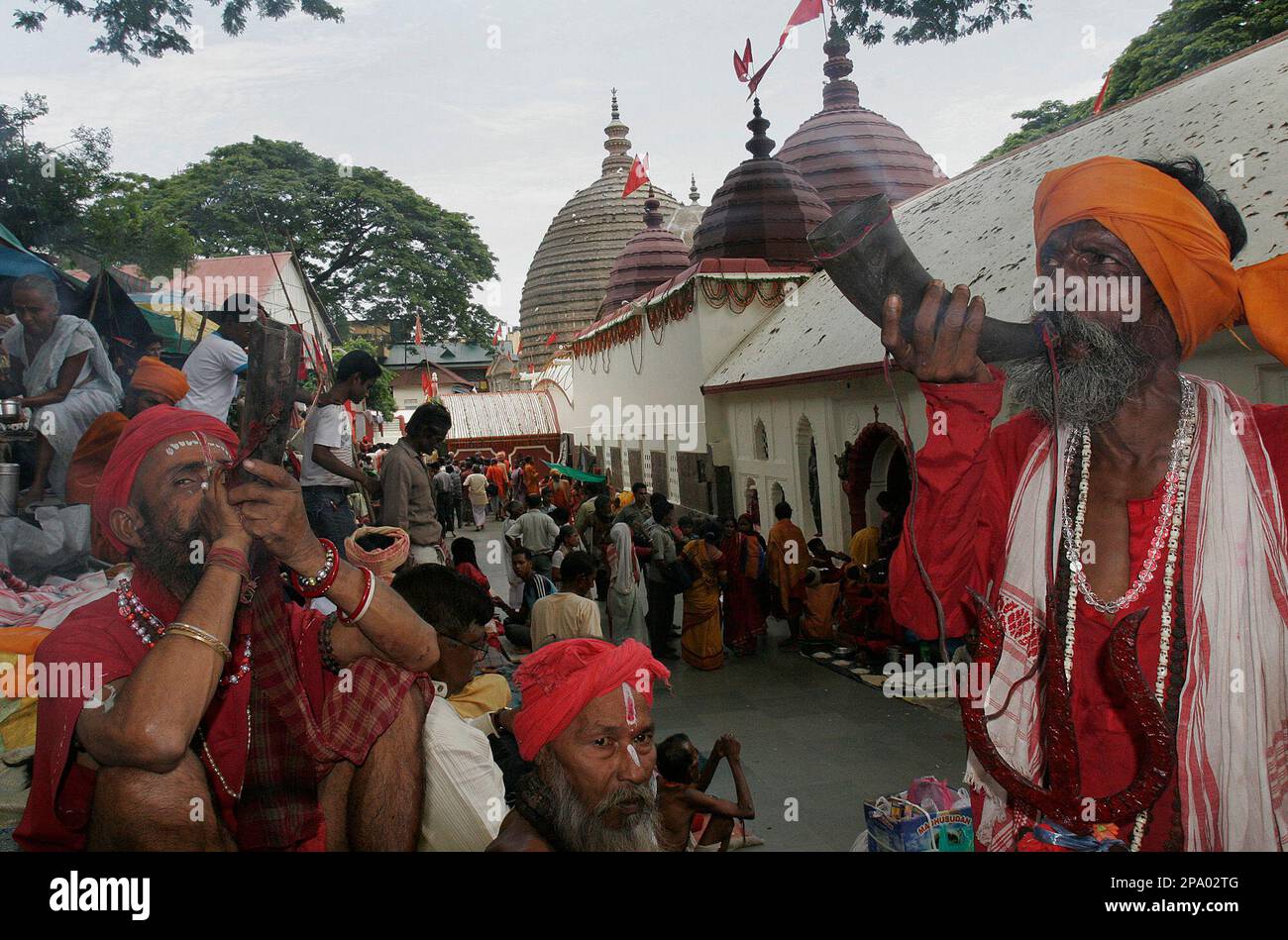 Sadhus or Hindu holy men blow buffalo horns during the Ambubasi