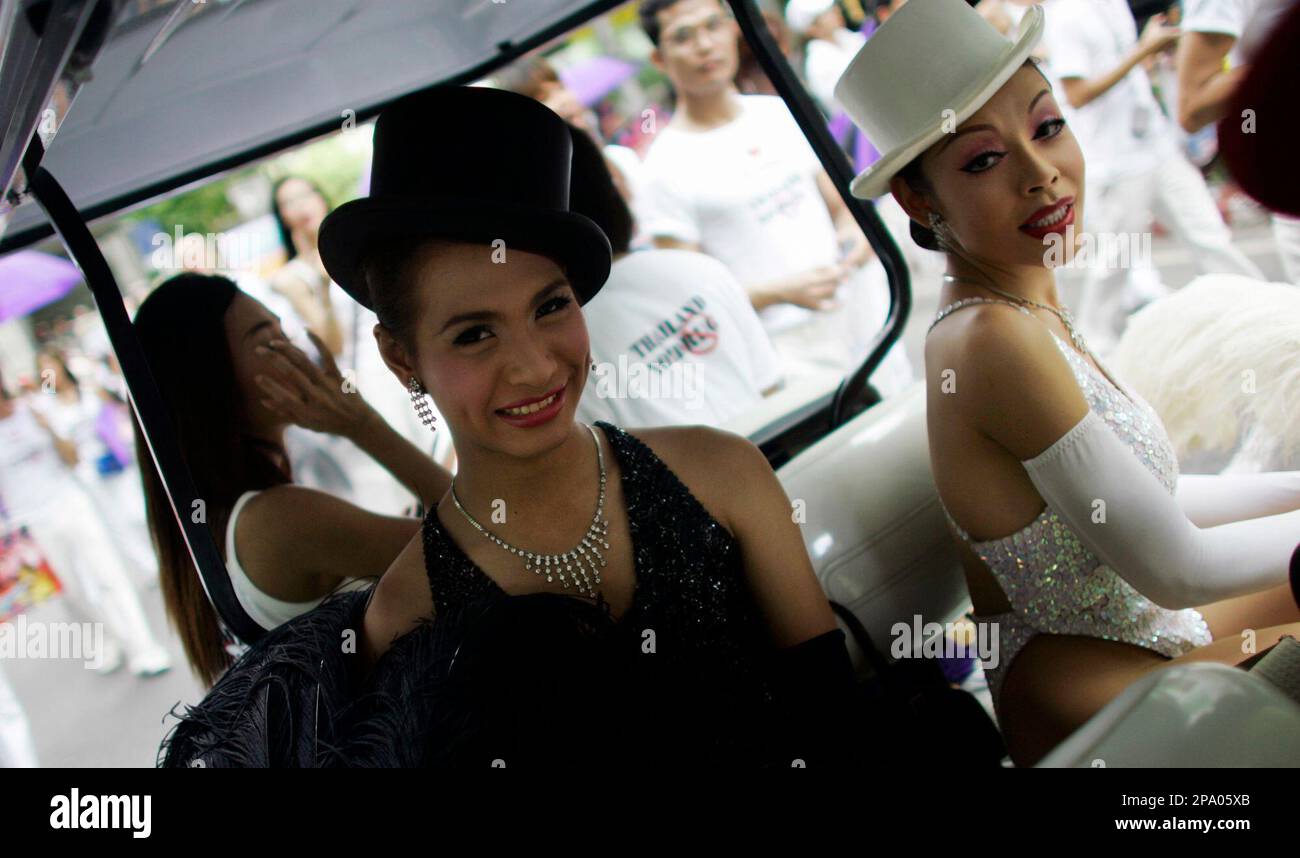 Transvestites from a Cabaret show smiles as they join Thai students and ...