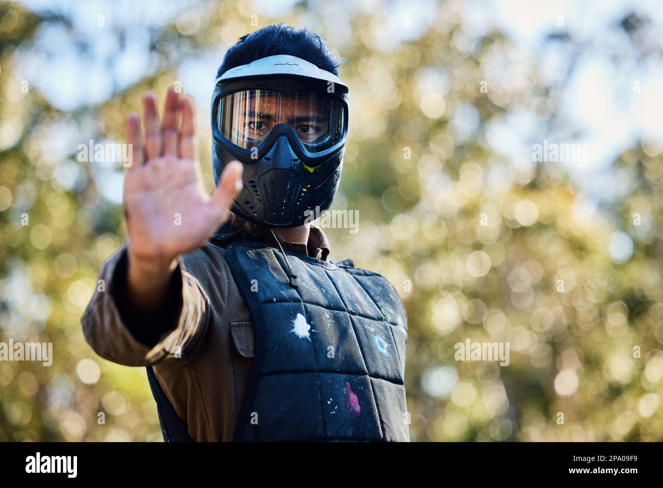 Man, paintball and hands in stop signal for team communication or