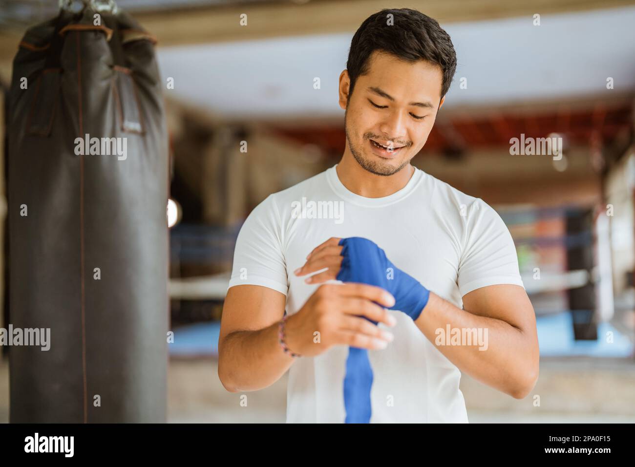 a asian male boxer wearing the boxing gloves while standing in ring Stock Photo
