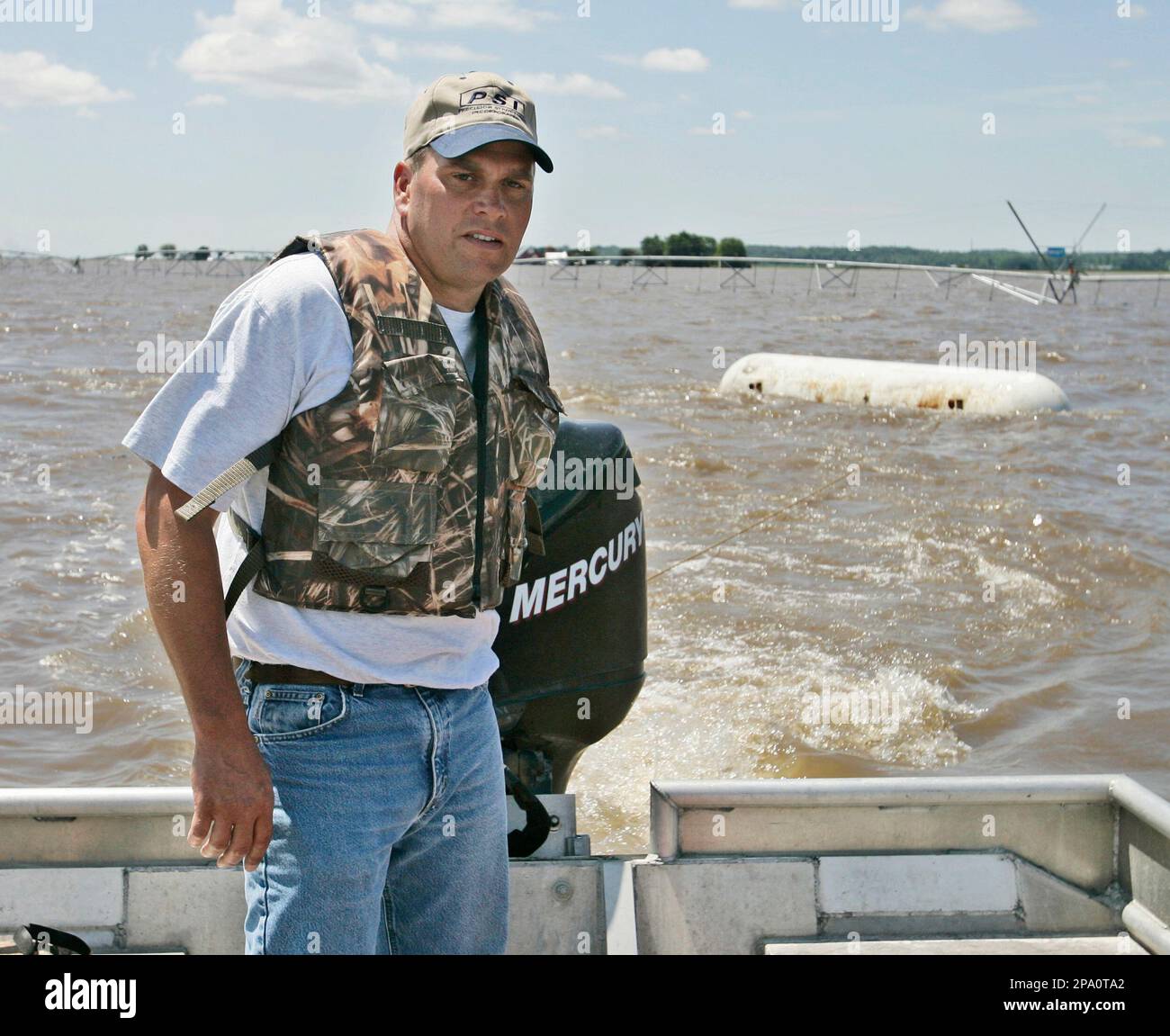 Jerry Edle pilots his boat through a flooded Iowa cornfield, towing a large propane tank which