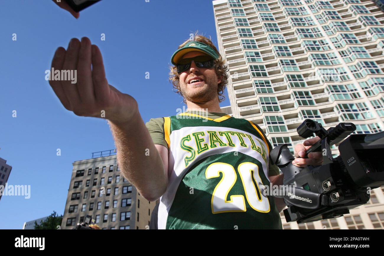 Seattle SuperSonics' fan Jason Reid reaches forward to have his wrist ...