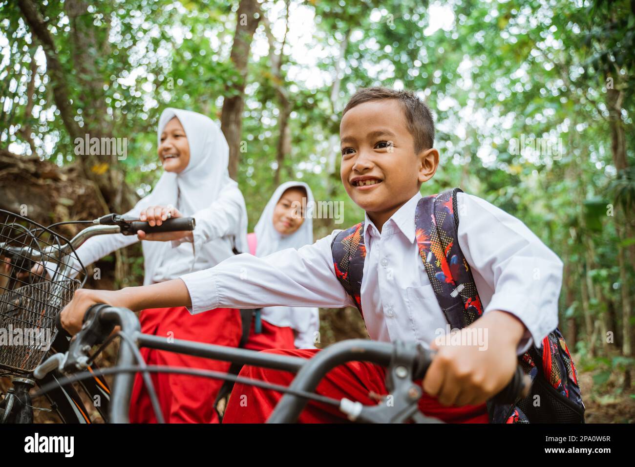 three elementary student riding their bike together Stock Photo