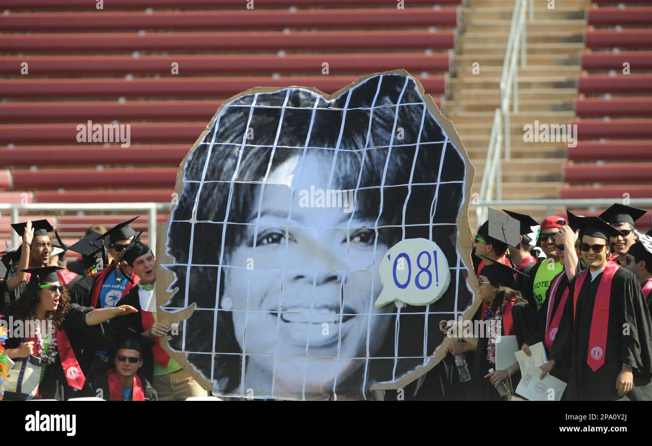 Stanford graduates carry a large photo of commencement speaker Oprah