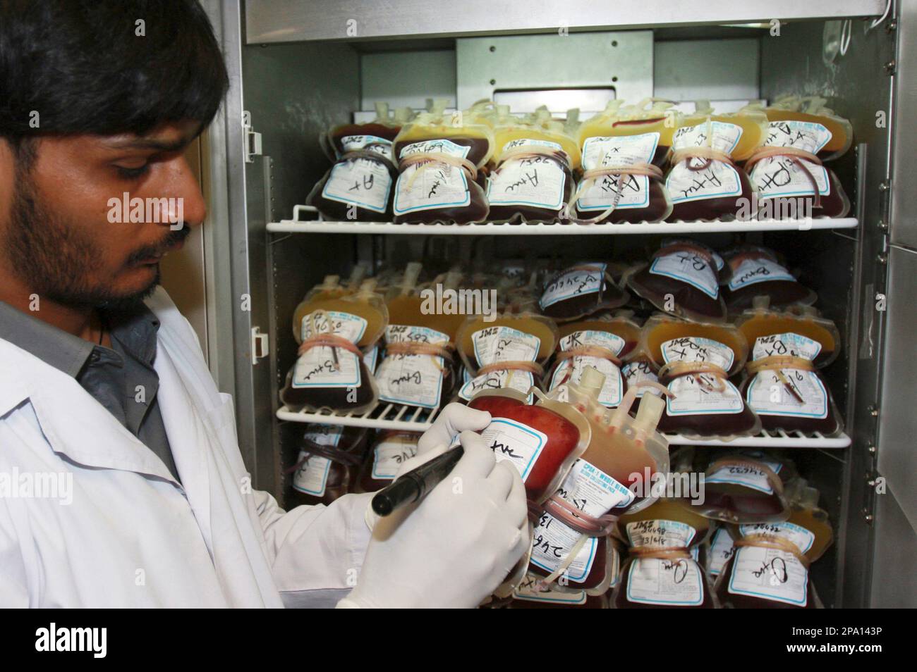 A Pakistani lab technician notes the blood given by a donor on World