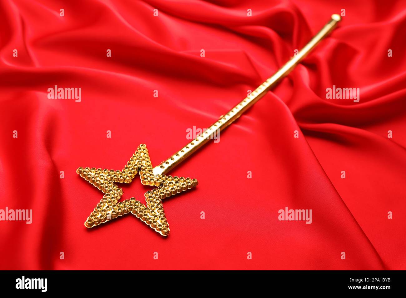 Beautiful golden magic wand on red fabric Stock Photo
