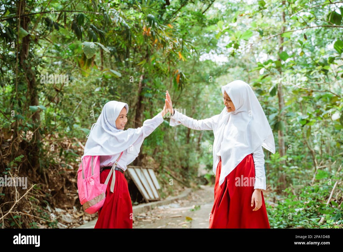 two female elementary students doing high five Stock Photo