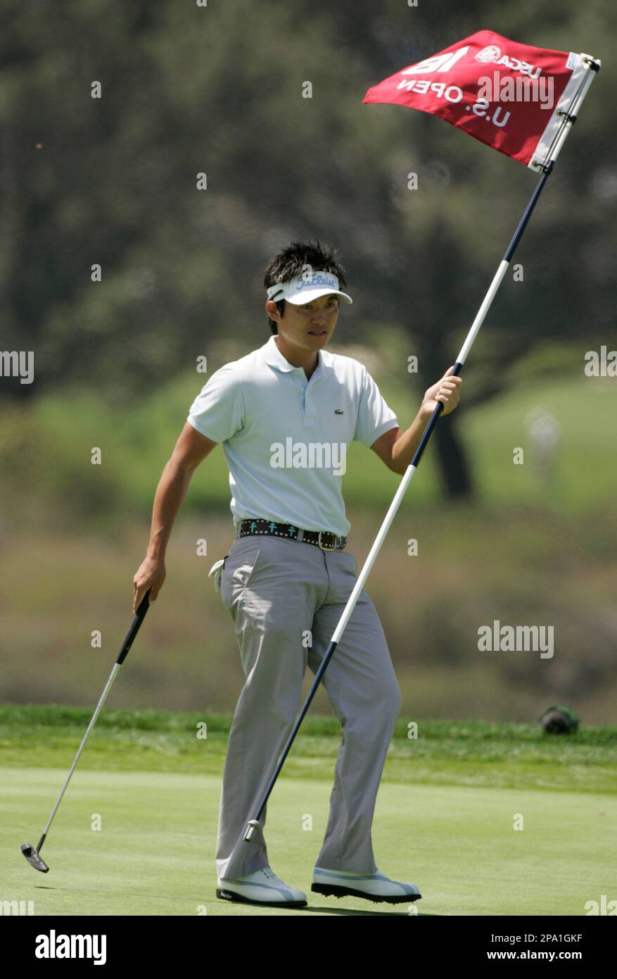 Ryuji Imada of Japan pulls the flag on the 16th green during his ...