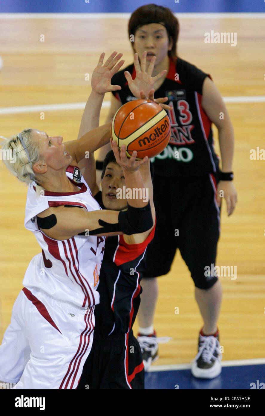 Japan's basketball player Sachiko Ishikawa, left, drives to the basket  against Latvia's player Liene Jansone during their preliminary round of the  FIBA Olympic qualifying tournament at the Arena Palace, in Madrid,  Wednesday,