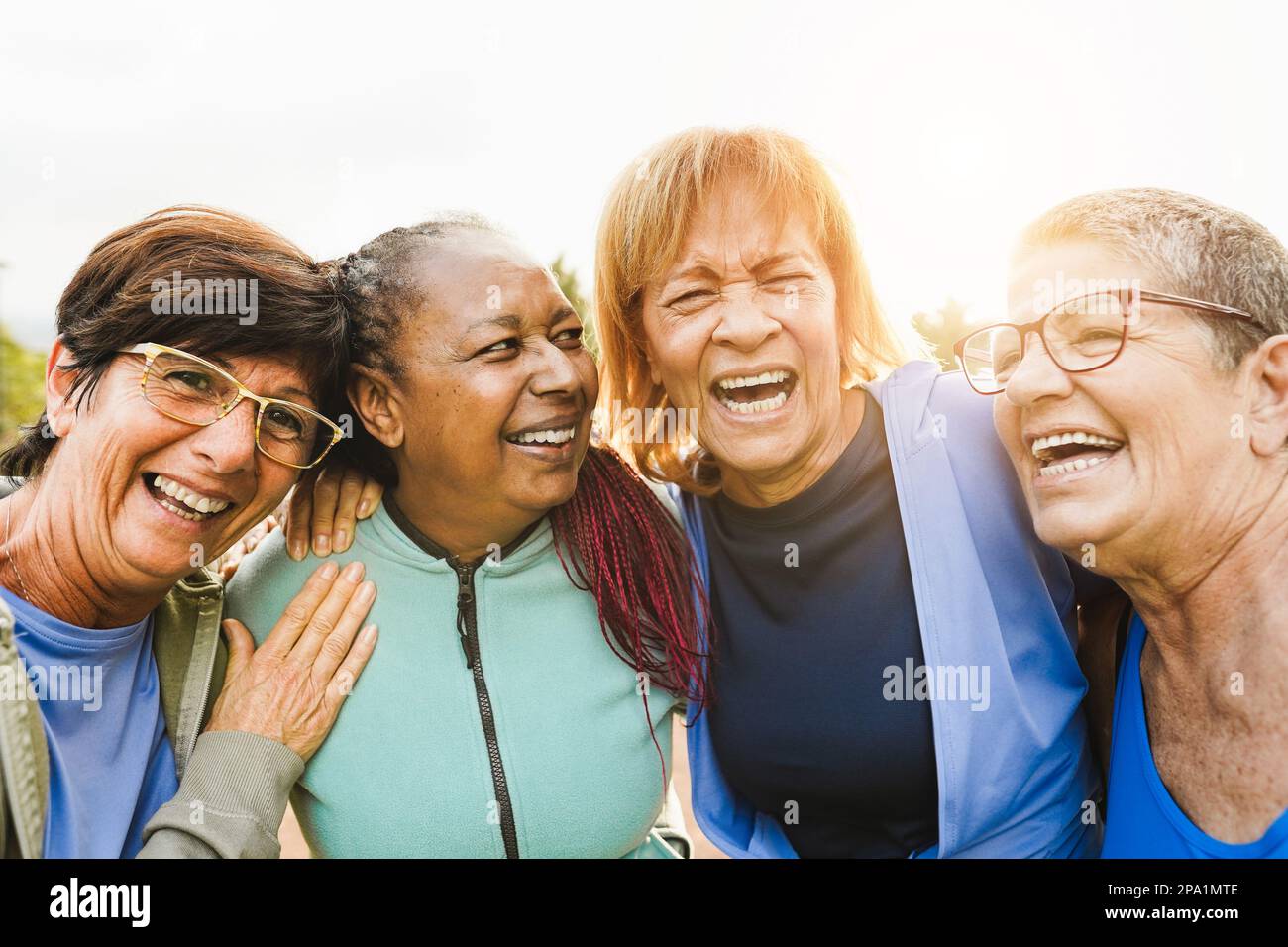 Multiracial senior women having fun together after sport workout outdoor - Healthy lifestye and mature people concept - Main focus on center women fac Stock Photo