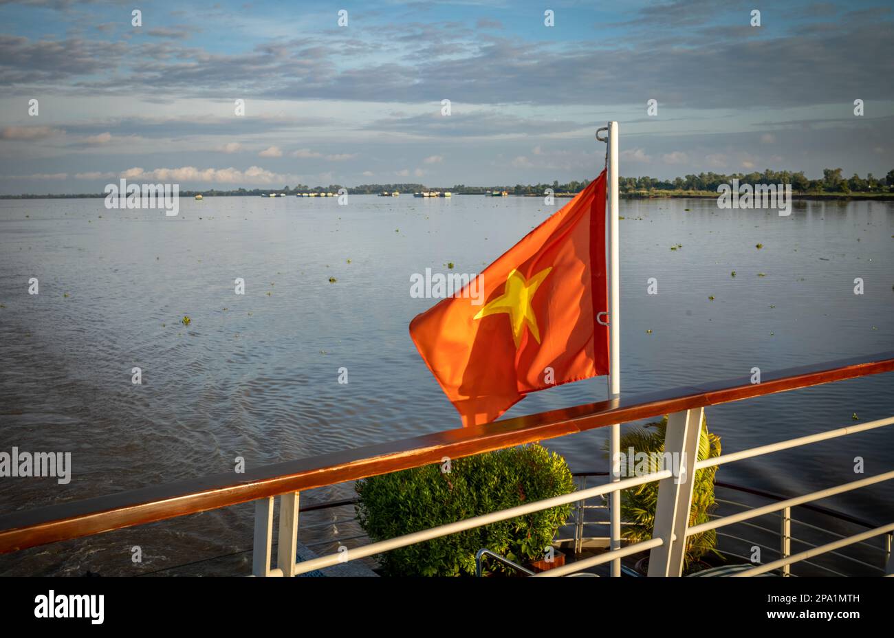 The stern of the Victoria Mekong river cruise ship flying the Vietnamese flag downstream from Phnom Penh on the Mekong River in Cambodia Stock Photo