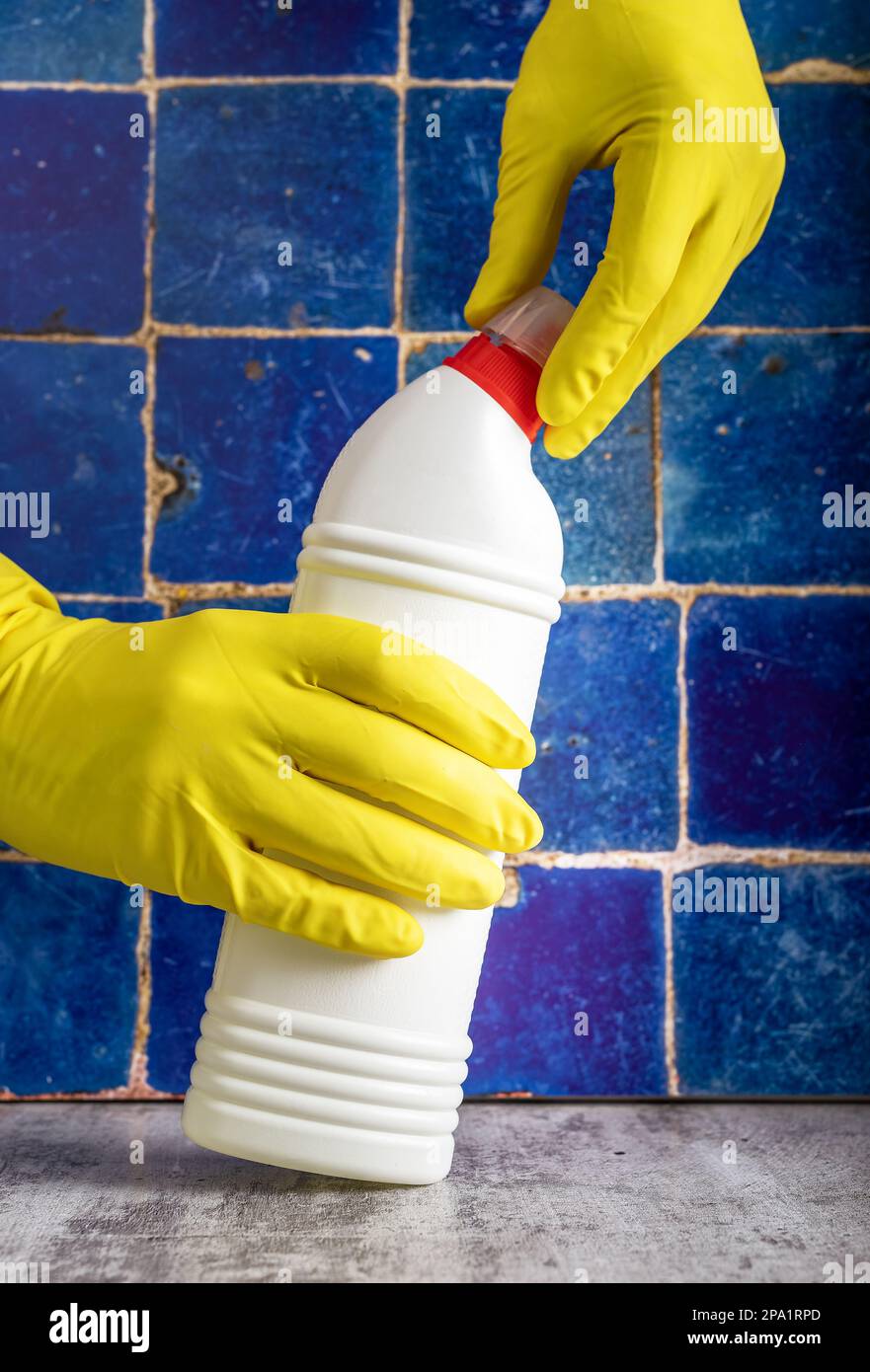 Detergent bottle in hands in gloves, opening WC and bathroom cleaning