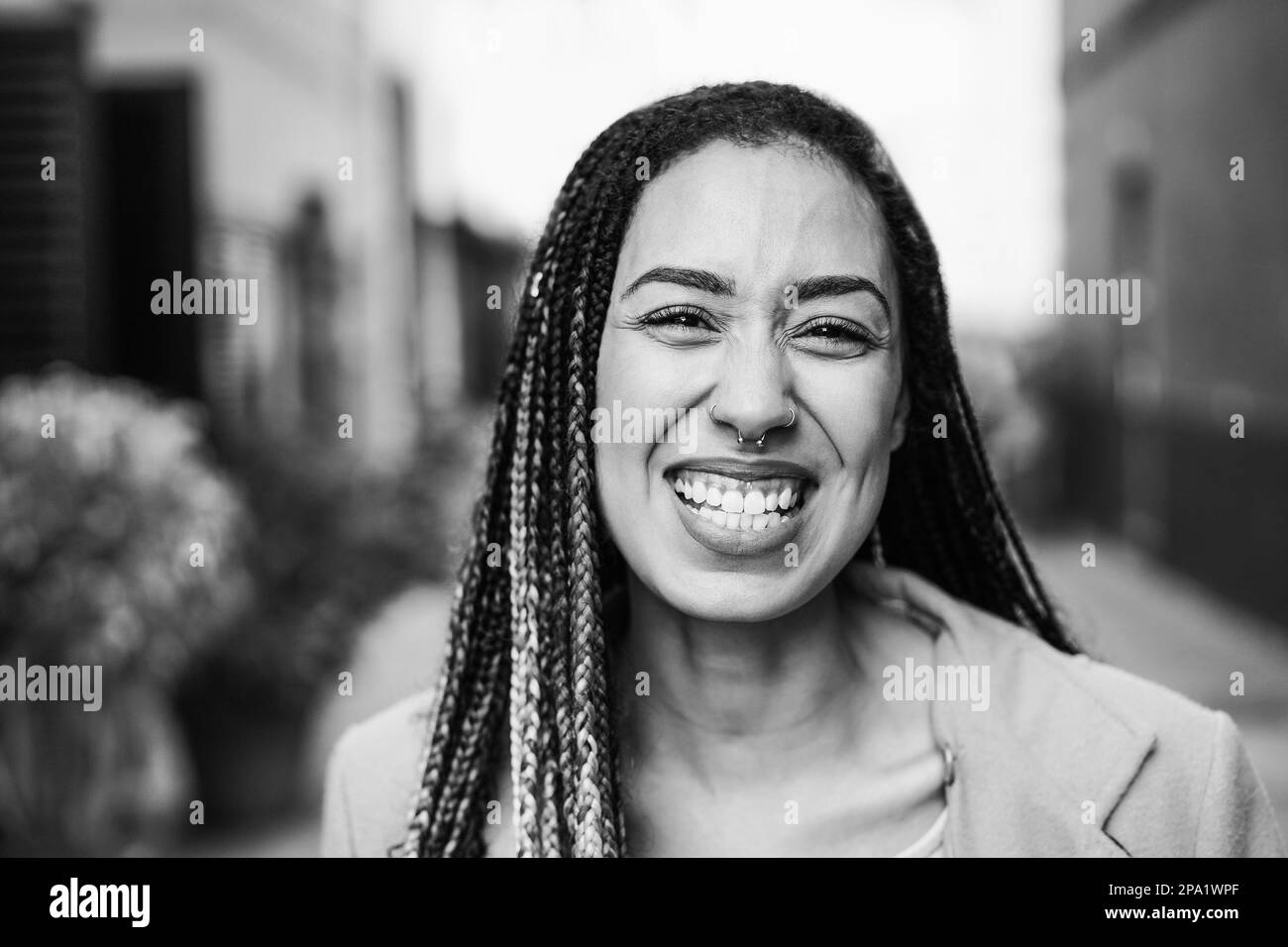 Mixed race girl smiling in front of camera during winter time - Focus on face - Black and white editing Stock Photo