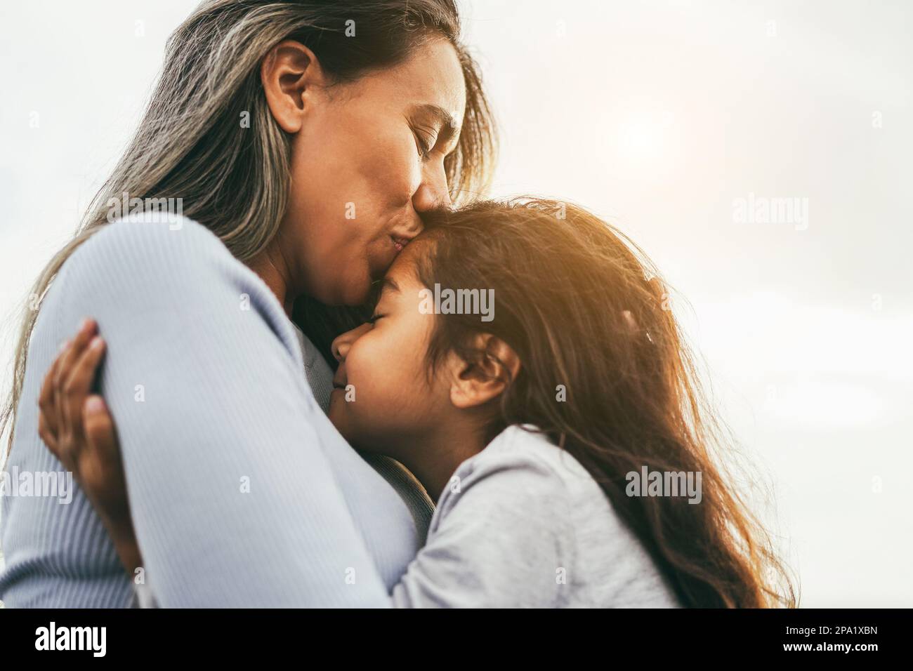 Happy latin mother and daughter having tender moment together outdoor