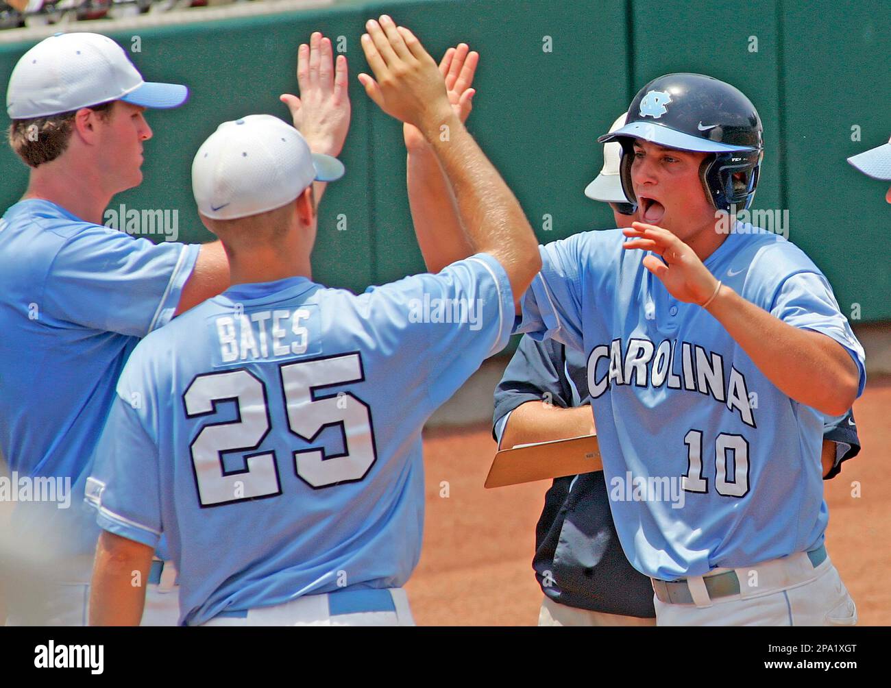 North Carolina's Kyle Seager (10) is congratulated on scoring a run during  the second inning against Coastal Carolina by teammates Colin Bates (25)  and Brett Thomas at a Super Regional NCAA college