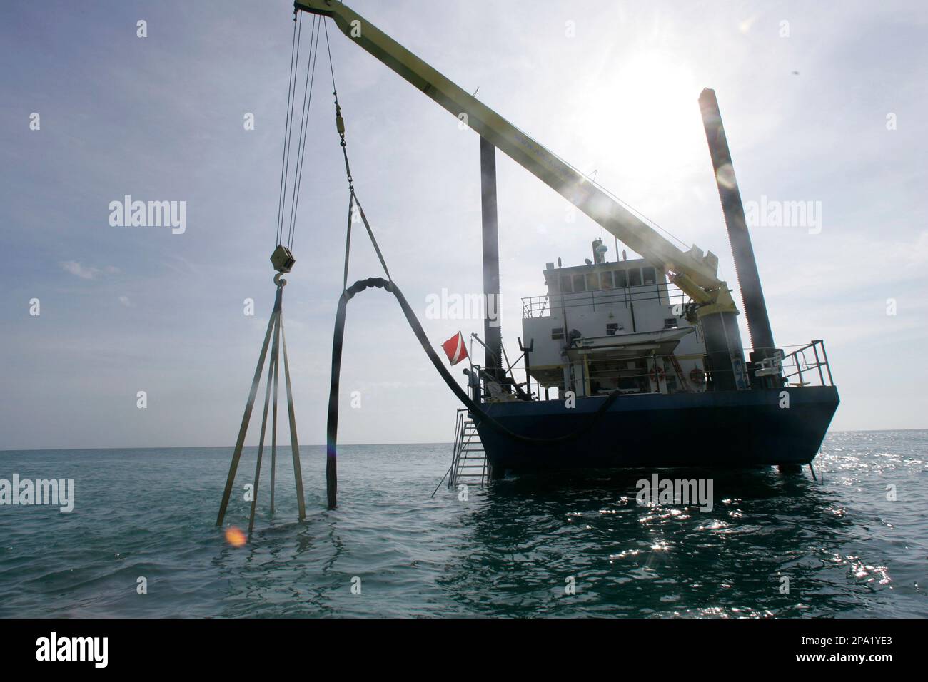 The Polly-L of Amelia Research & Recovery blows a large hole in the sand  with twin blowers suspended from a crane as its crew looks for remnants of  a ship believed to