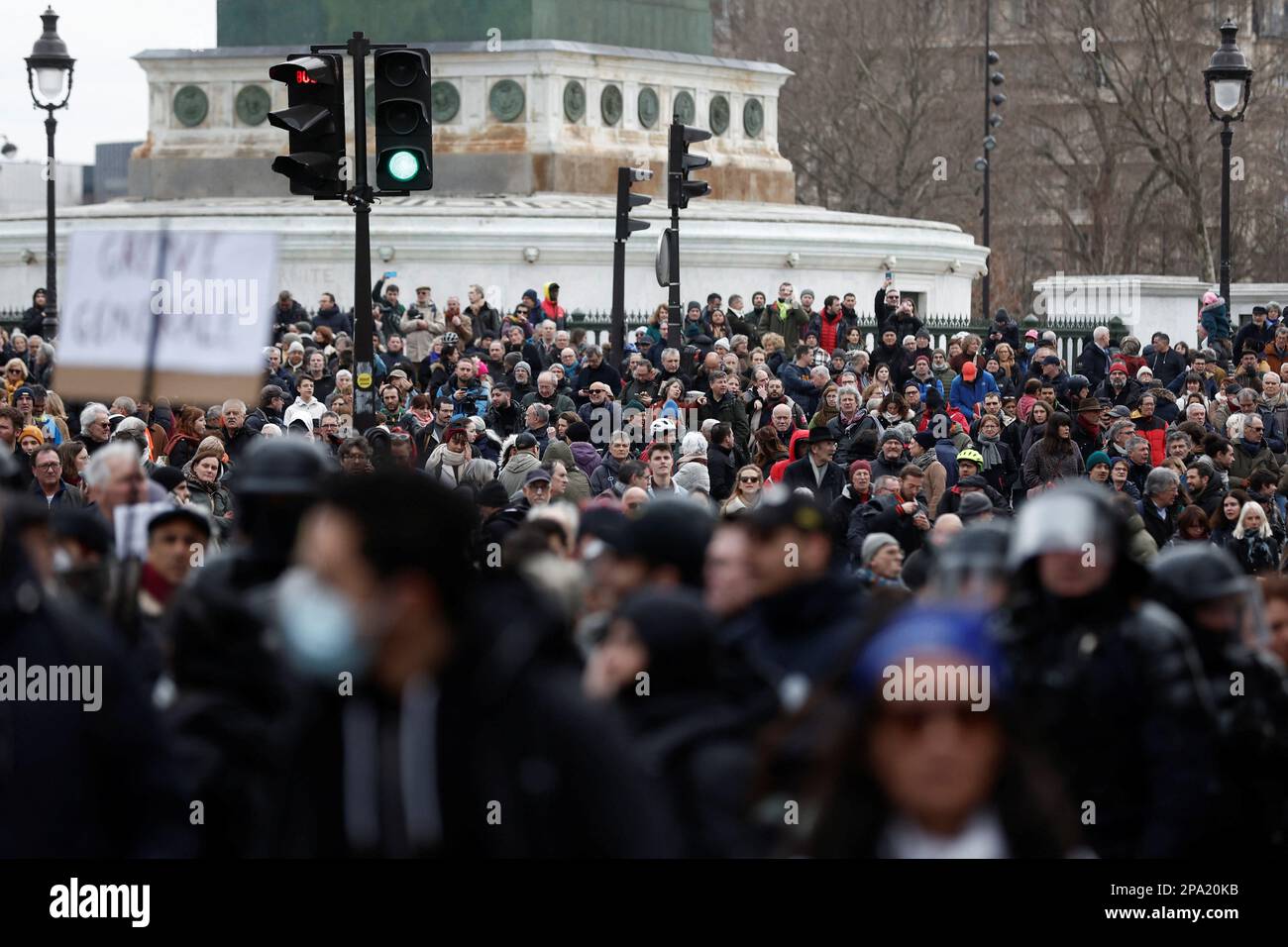 Riot police (foreground) gather among demonstrators at a march against the government's pension reform plan in Paris, France, March 11, 2023. REUTERS/Benoit Tessier Stock Photo