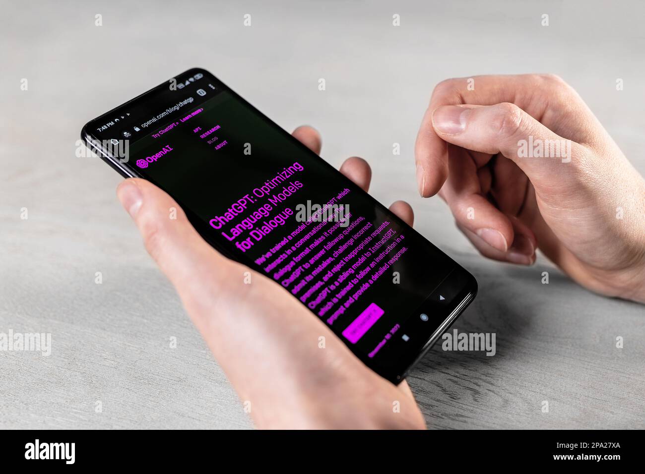 Lodz, Poland March 01 2023 Hands with phone screen, Open AI homepage, website. Using Chat GPT, online bot service, chatbot on smartphone display at de Stock Photo
