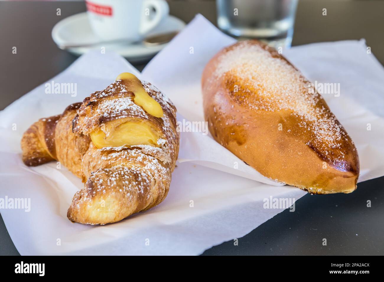 Syracuse in Sicily, Italy. Traditional fresh brioches with cream served at bar table as breackfast. Natural light, no studio Stock Photo