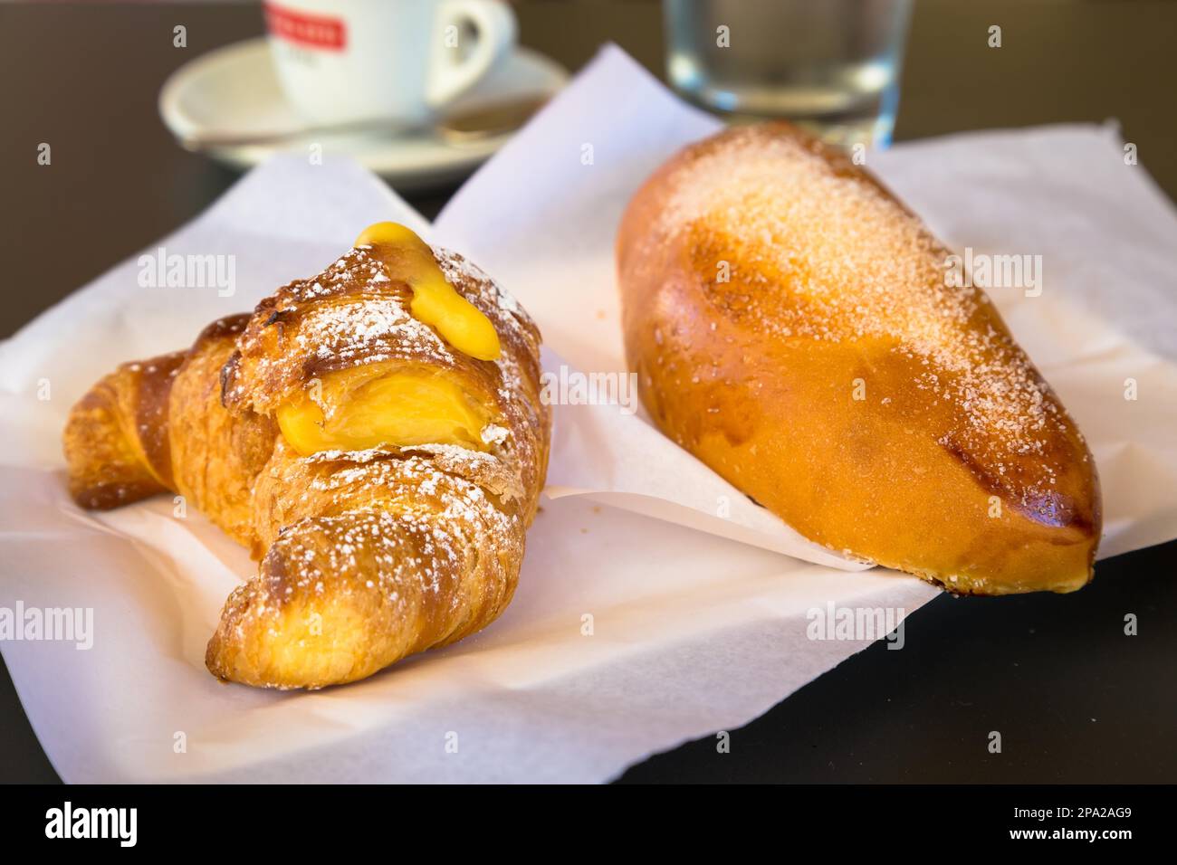 Syracuse in Sicily, Italy. Traditional fresh brioches with cream served at bar table as breackfast. Natural light, no studio Stock Photo