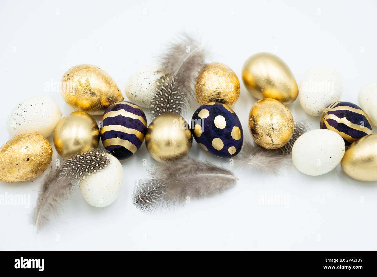 Easter golden and black eggs, feather. Stock Photo