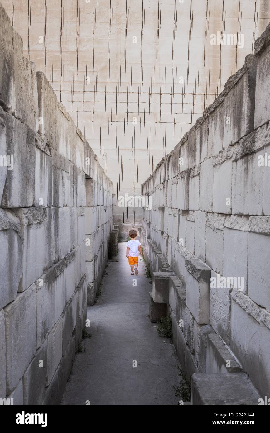 Caucasian young kid walking with labyrinth perspective. Conceptual image for dangerous situation during childhood Stock Photo