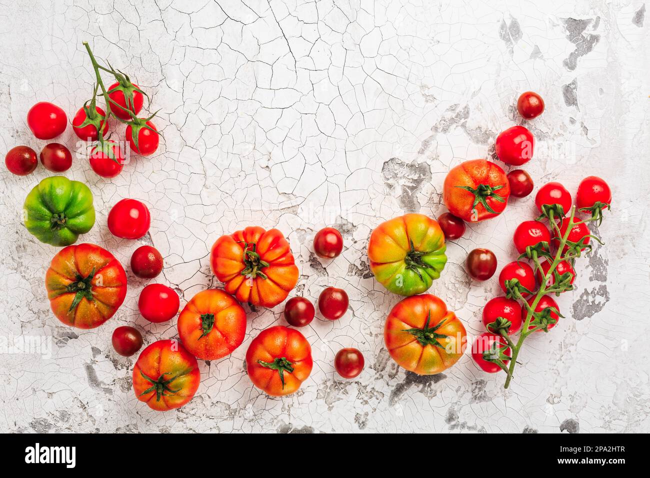 Assortment of organic tomatoes on old kitchen table Stock Photo