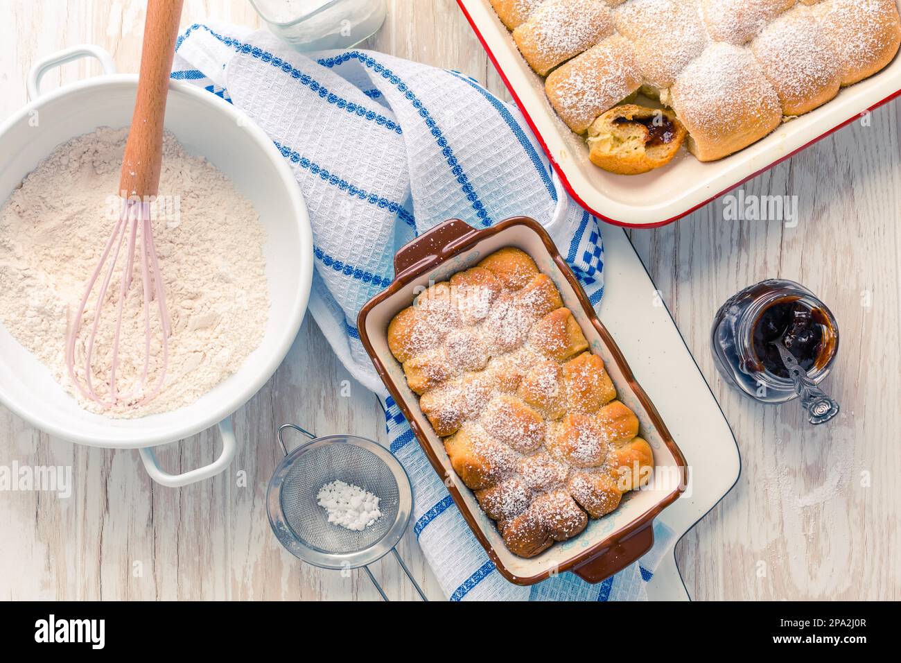 Sweet rolls, Buchteln filled with plum jam or jelly with backing ingredients Stock Photo