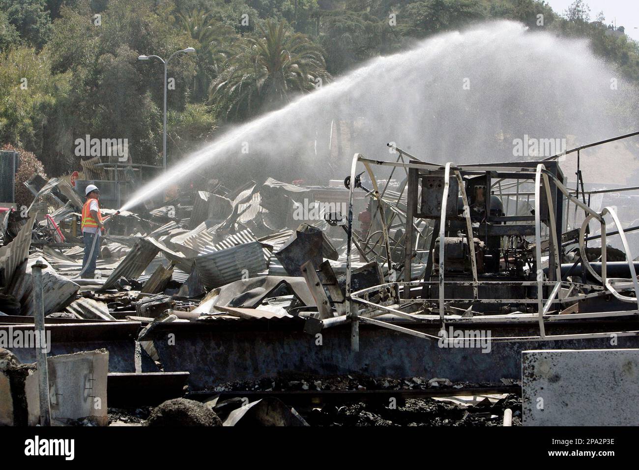 Ted Wayman, a Universal Studios' worker, hoses down the area outside the King Kong attraction Monday, June 2, 2008, at the Universal Studios Hollywood back lot, a day after a fire destroyed the sets of iconic films, in the Universal City section of Los Angeles. (AP Photo/Ric Francis) Stock Photo
