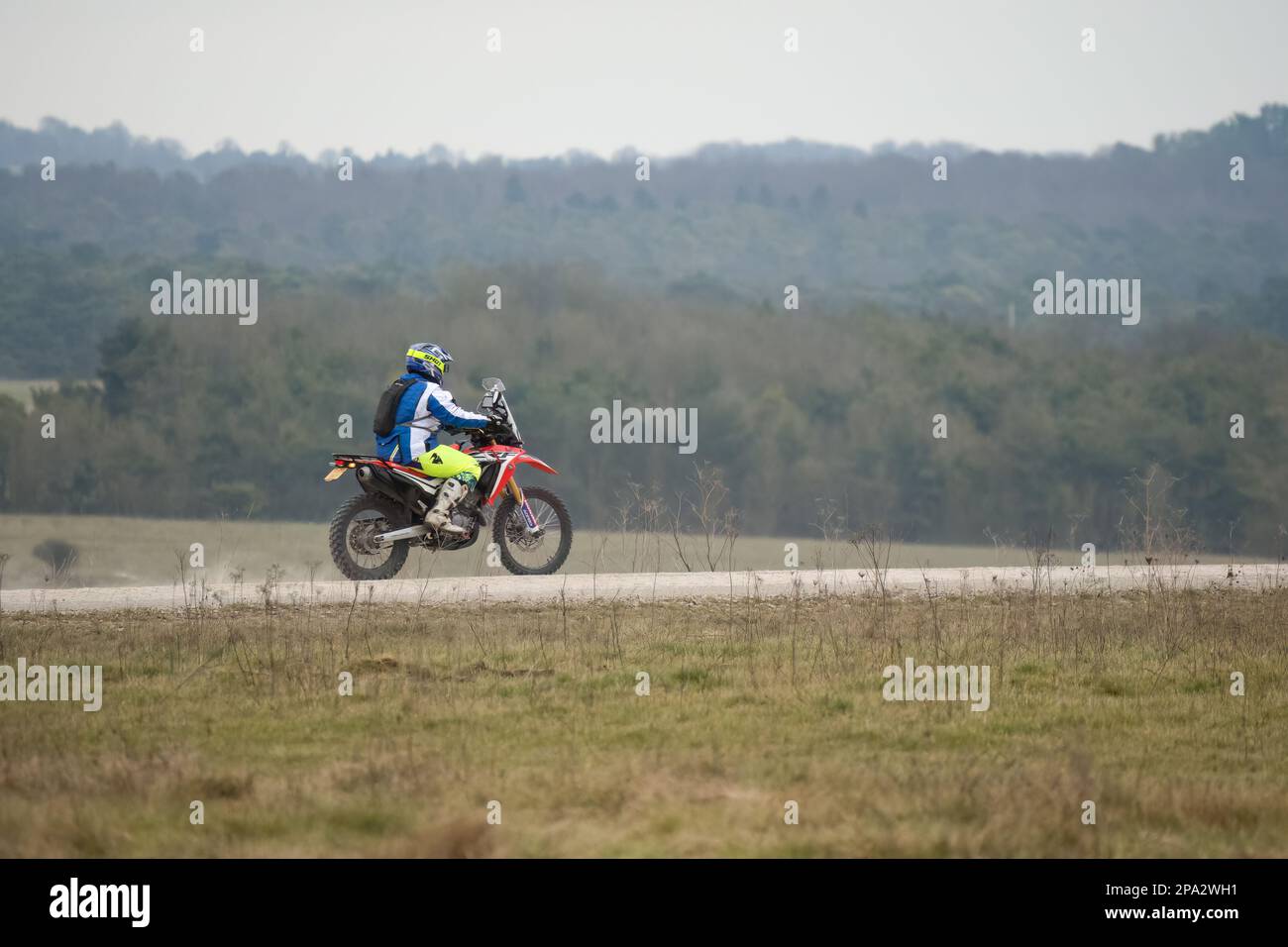 a young motor cyclist (biker) riding his offroad motorbike along a