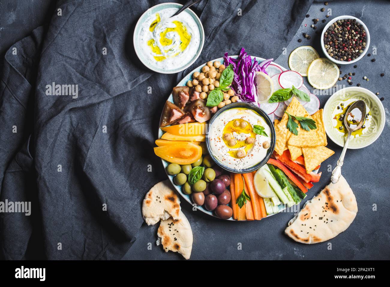 Meze platter with hummus, yoghurt dip, assorted snacks. Space for text. Hummus, vegetables