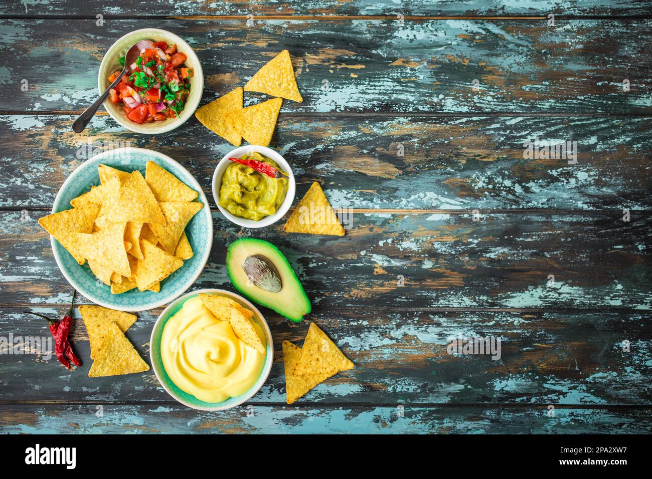 Mexican tortilla chips with guacamole, cheese, salsa dips. Space for