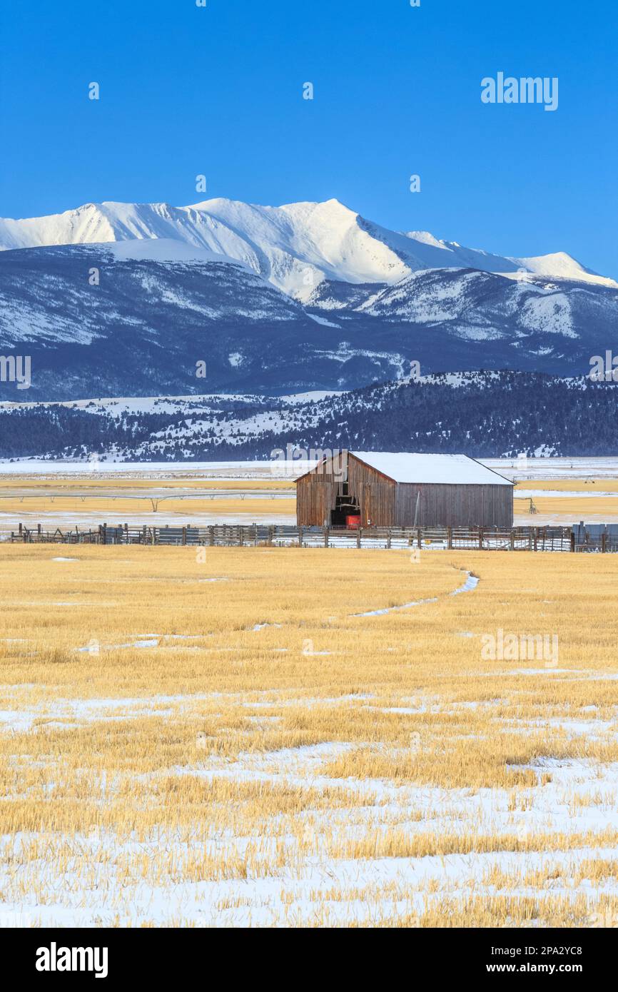 barn and farm fields below mount haggin in winter near anaconda