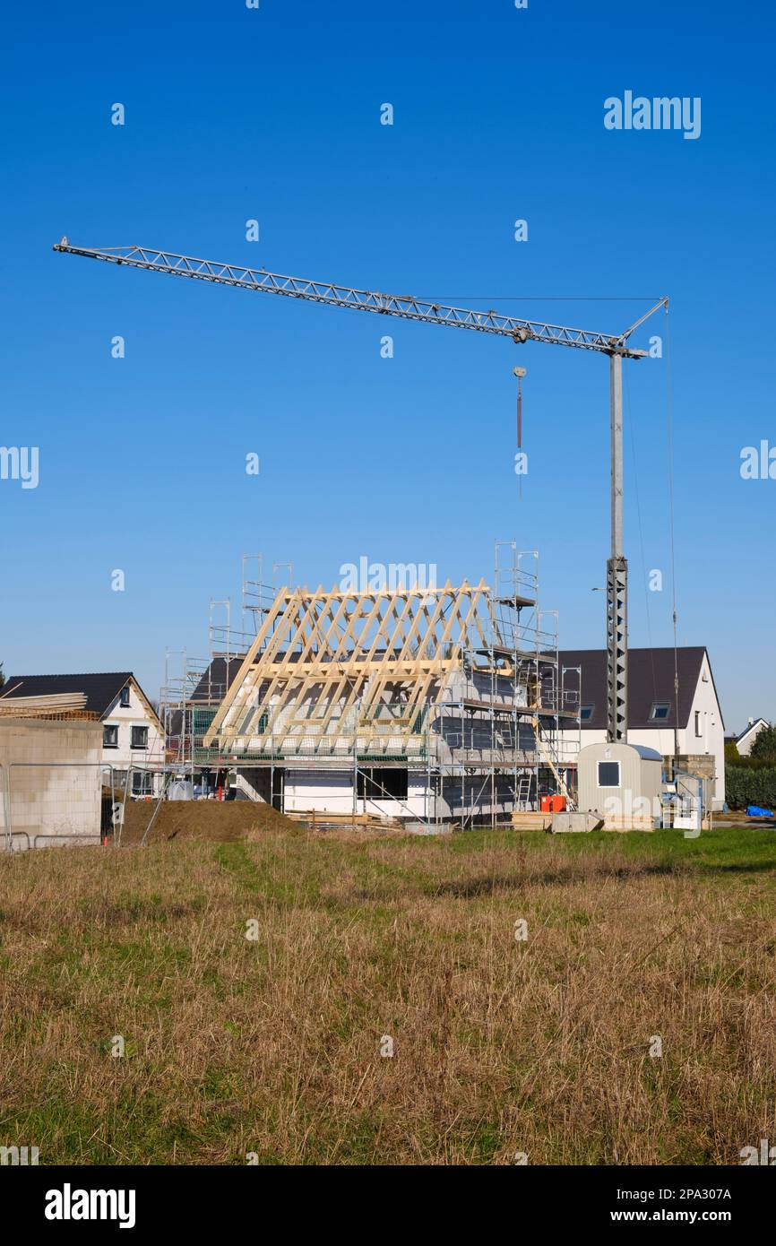 Residential house with scaffolding and open roof truss, construction