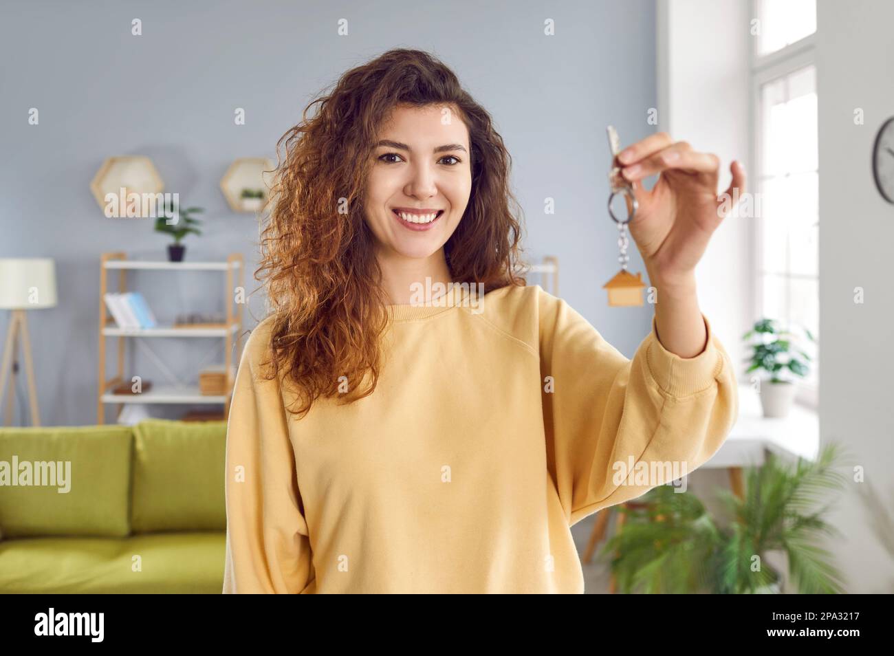 Happy young woman holding keys to her new apartment Stock Photo - Alamy