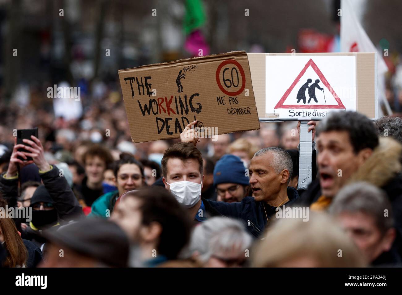Demonstrators hold placards during a march against the government's pension reform plan in Paris, France, March 11, 2023.  REUTERS/Benoit Tessier Stock Photo
