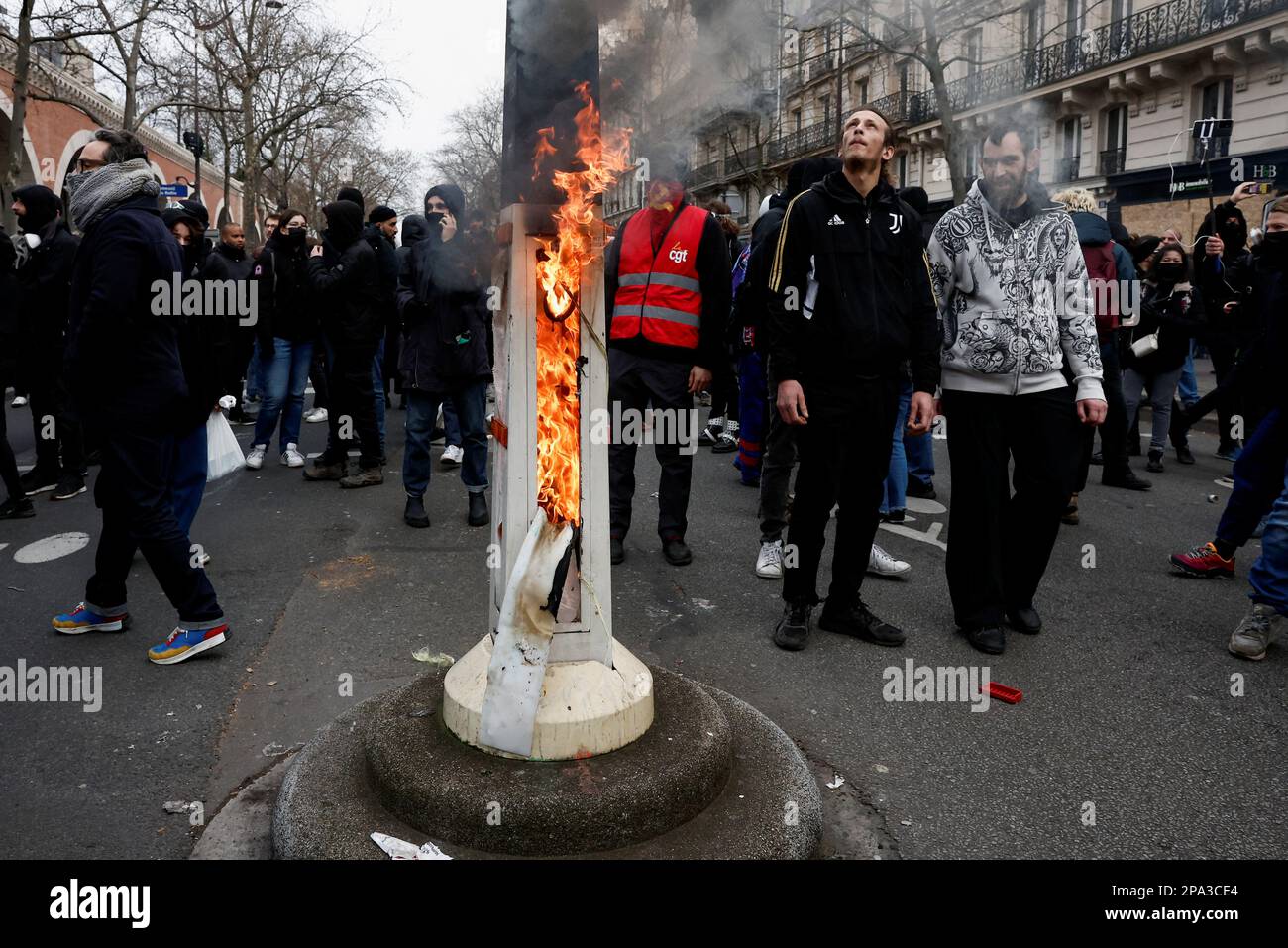 People walk next to a flame during a march against the government's pension reform plan in Paris, France, March 11, 2023.  REUTERS/Benoit Tessier Stock Photo