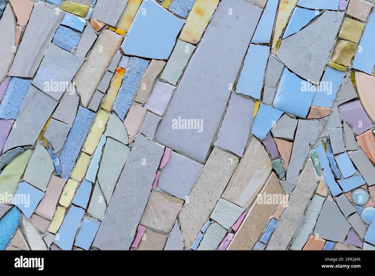 Abstract mosaic of pieces of ceramic tiles and natural stones. Mosaic background and texture. Stock Photo