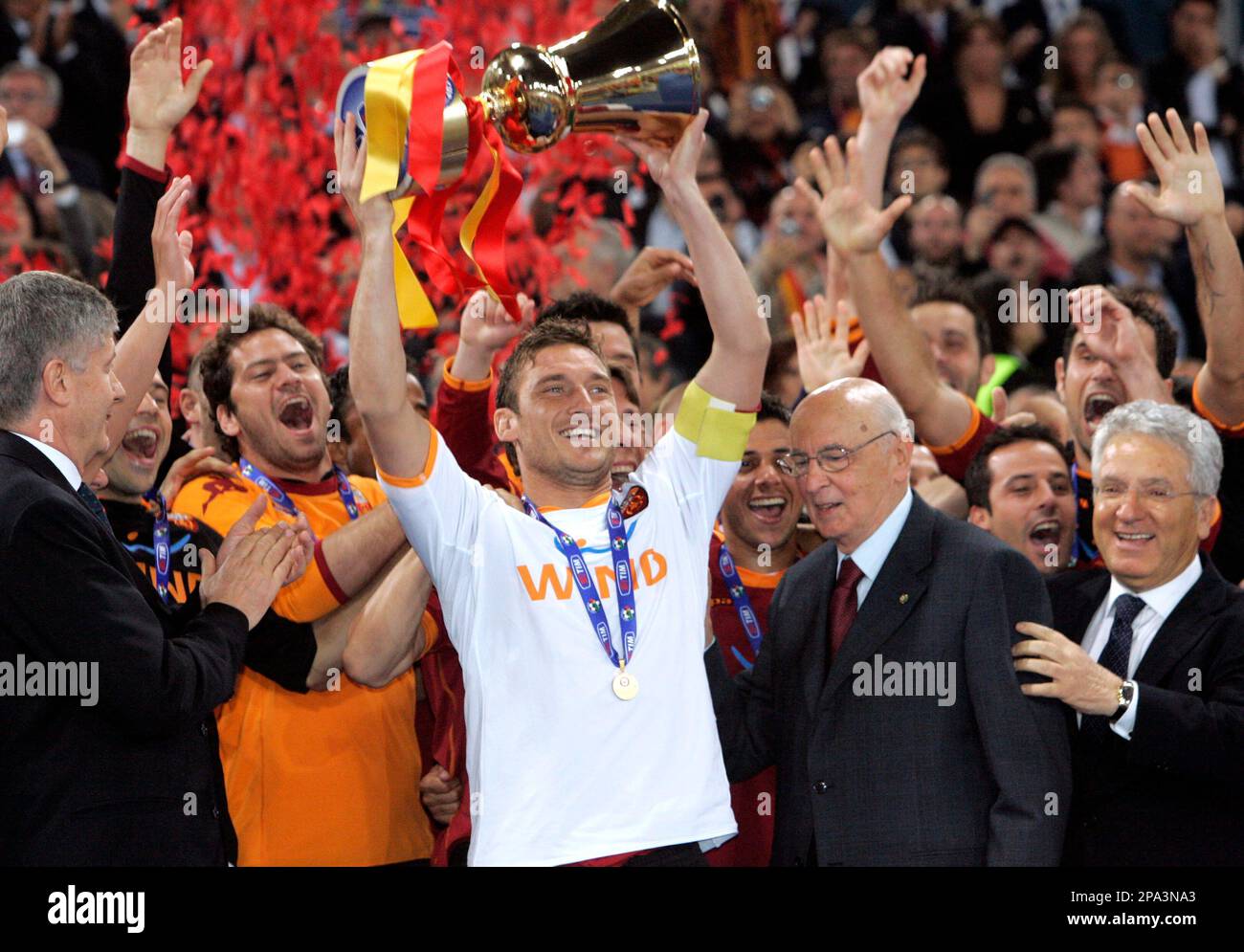 AS Roma's captain Francesco Totti, center with white jersey, sorrounded by  teammetes, holds the trophy with Italian President Giorgio Napolitano,  second from right, and Italian soccer league president Antonio Matarrese,  right, after