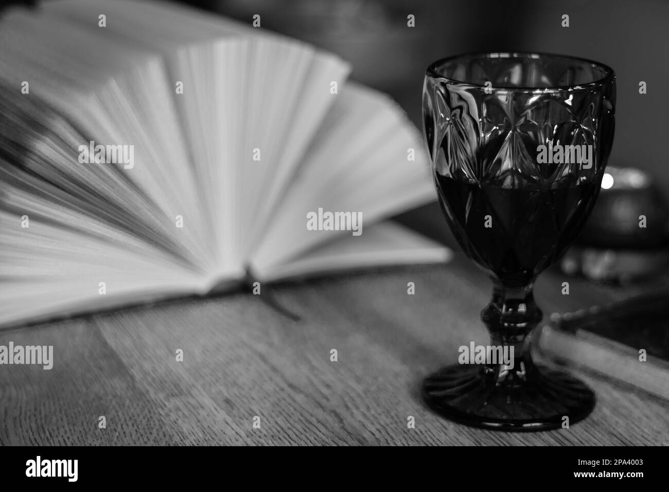 Open book with glass of wine, black and white. Open book with wineglass. Education concept. Reading books. Literature background. Wisdom and knowledge Stock Photo