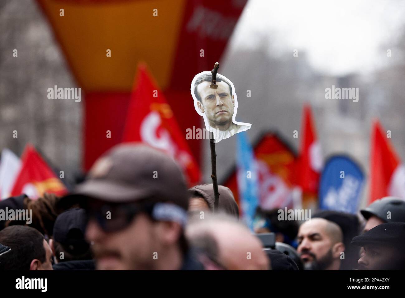 A demonstrator holds an image depicting French President Emmanuel Macron on a stick, during a march against the government's pension reform plan in Paris, France, March 11, 2023.  REUTERS/Benoit Tessier Stock Photo