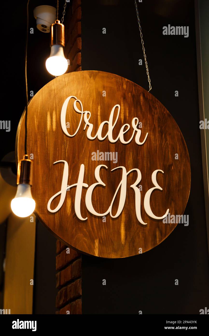 Restaurant service sign Order Here in modern loft style. Can be used in coffee shops, cafes, fast food restaurants Stock Photo