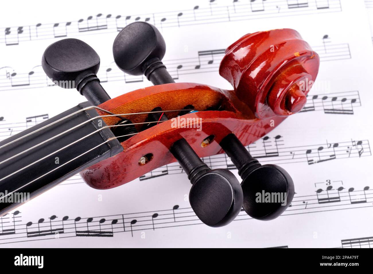 violin made of rosewood against a white background with music sheet