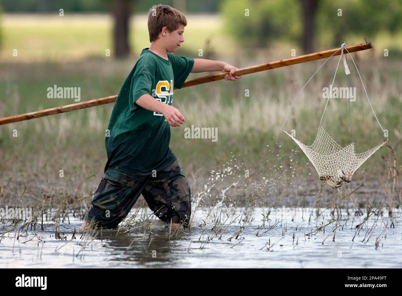 Toby Williams, 13, of Independence, La. catches crawfish Monday, May 19, 2008 in the Bonnet Carre Spillway near Norco, Louisiana. The Spillway was opened for four weeks to lower the level of the Mississippi River as it passes New Orleans. With the Spillway now closed crawfish can be found in abundance. (AP Photo/Tim Mueller) Stock Photo