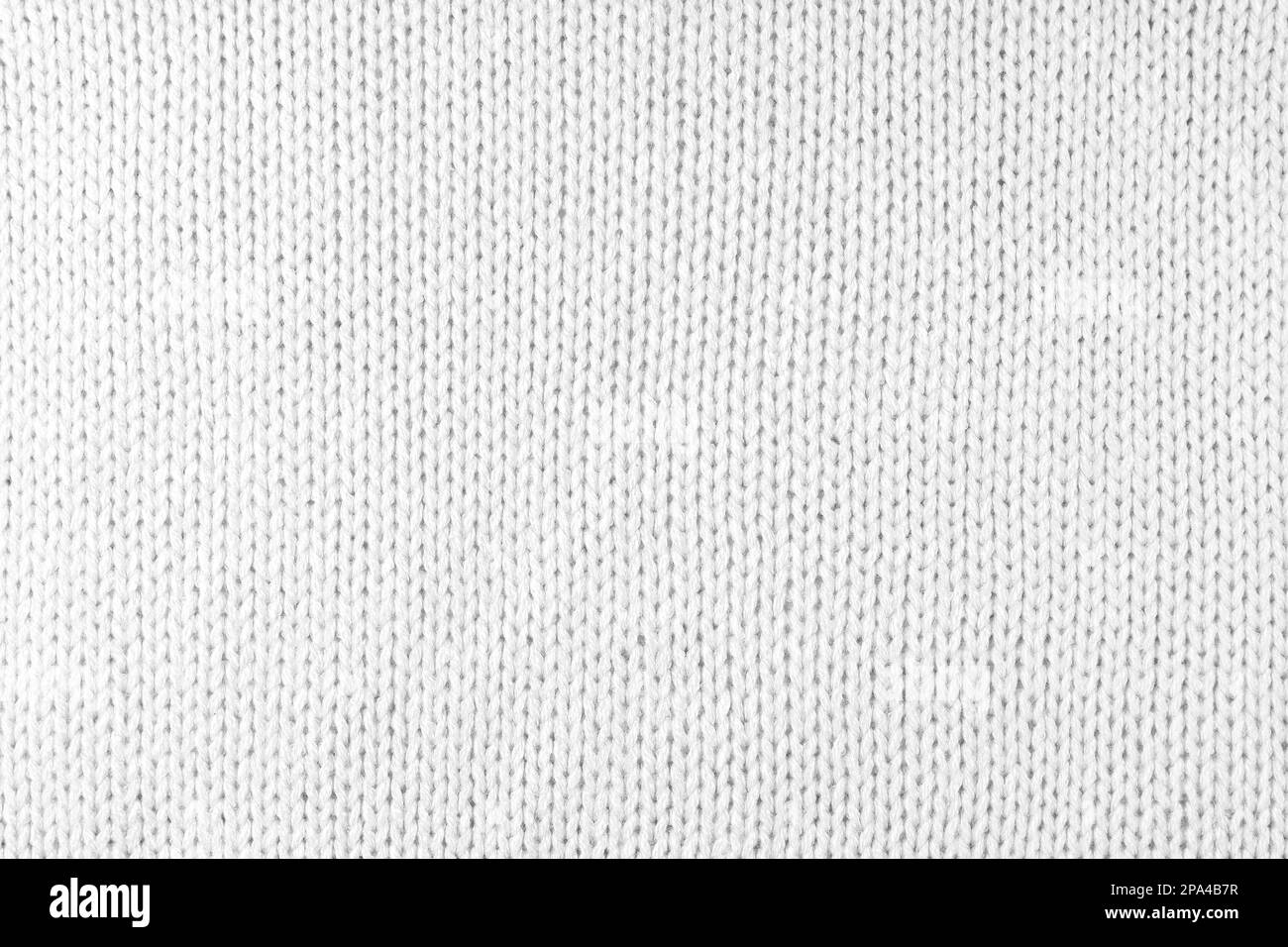 Close up background of knitted wool fabric made of viscose yarn. White color wool knitwear texture. Abstract knitted jersey background. Fabric abstrac Stock Photo