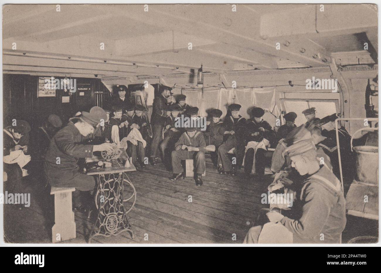 Royal Navy sailors in a sewing class on board ship. Most of the men are