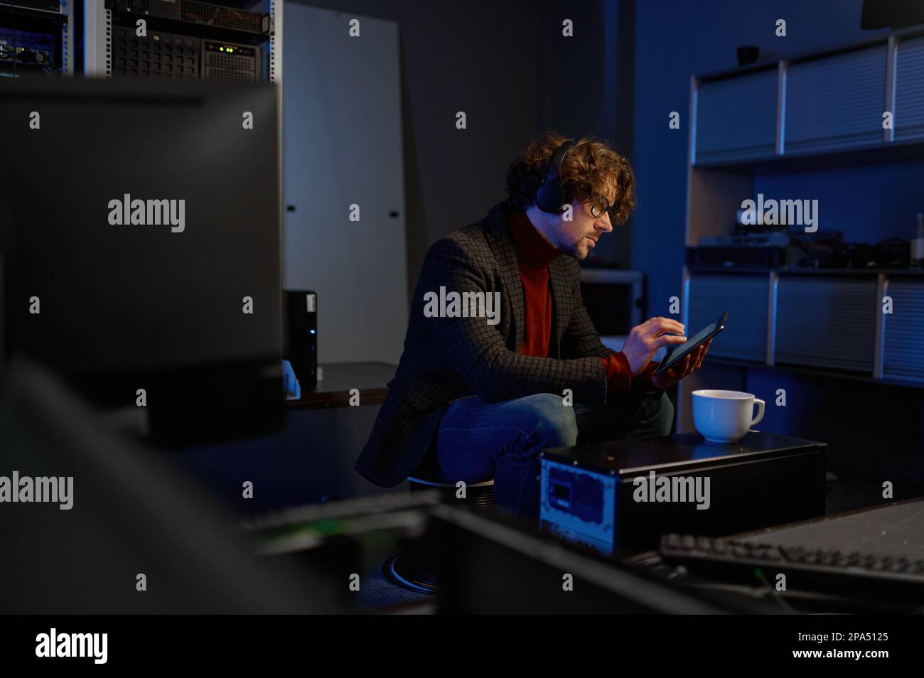 IT technician using digital tablet while working in data center Stock Photo